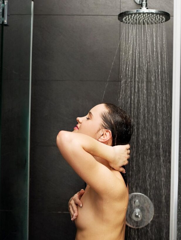 Девушка в душевой кабинке принимает душ